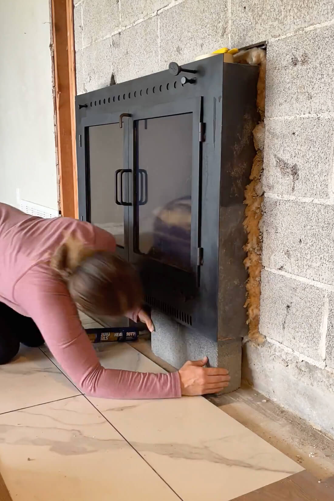 Using liquid nails to glue down a hearth stone.